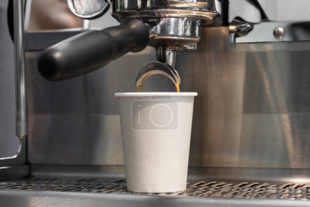 Téléchargez les photos : Café infusé extrait d'une machine à café professionnelle équipée d'un filtre sans fond. - en image libre de droit