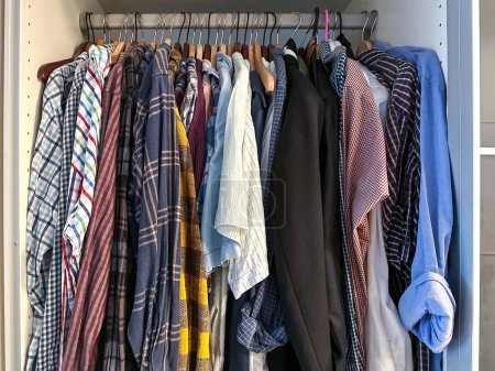 Photo for Wardrobe with shirts hanging on row in home. - Royalty Free Image
