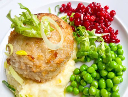 Photo for Plate of the dish Wallenbergare with mashed potatoes, green peas and lingonberries. Sweden - Royalty Free Image