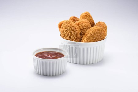 Téléchargez les photos : Délicieuse portion de pépites de poulet, sur un ramequin blanc, avec du ketchup sur le côté, isolée - en image libre de droit