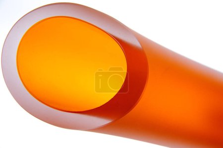 Foto de Primer plano de la punta de un tubo naranja brillante, aislado sobre fondo blanco - Imagen libre de derechos
