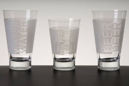 Set of three glasses with "water and beer" written on them, isolated