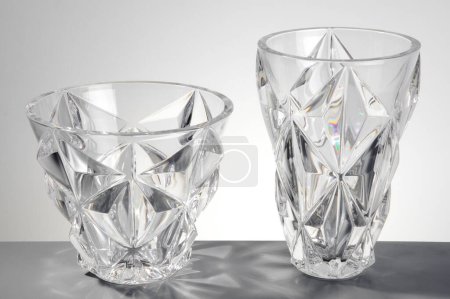 Pair of transparent glass vases with edges, isolated