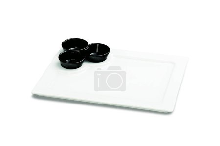 Téléchargez les photos : Kit avec plaque de service rectangulaire en céramique blanche, avec trois ramequins noirs, isolé sur blanc - en image libre de droit