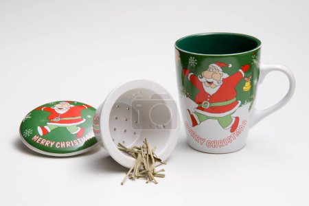 Photo for Kit of ceramic mug, infuser and a lid, with a santa claus illustration, isolated - Royalty Free Image