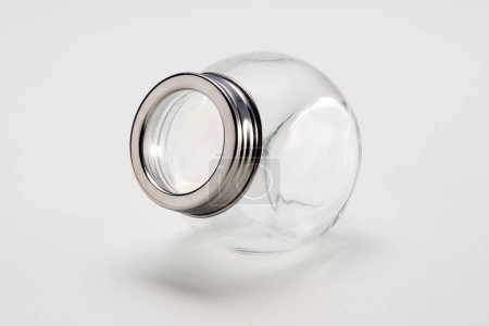 Foto de Frasco de vidrio redondo vacío con tapa de plata, aislado en blanco - Imagen libre de derechos
