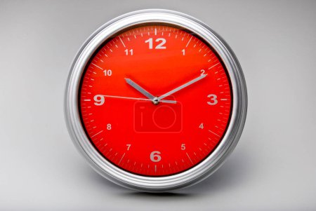 Foto de Reloj de pared redonda con fondo rojo, aislado - Imagen libre de derechos