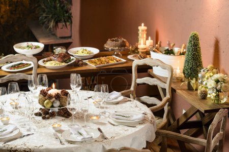 Foto de Hermosa mesa de cena de Navidad, con buffet de fondo, postre, champán y decoración típica. - Imagen libre de derechos
