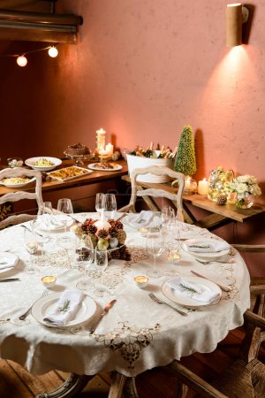 Foto de Magnífica mesa de cena de Navidad, con buffet de fondo, postre, champán y decoración típica. - Imagen libre de derechos