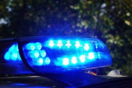 Téléchargez les photos : Lumière bleue d'urgence sur le toit de la voiture de police ou le véhicule de secours la nuit - en image libre de droit