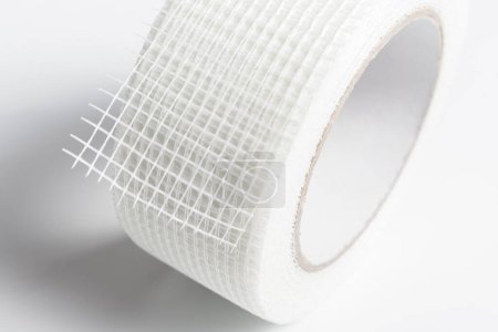 Foto de Rollo de cinta de junta de paneles de yeso blanco, rollo de fibra de vidrio autoadhesiva - Imagen libre de derechos