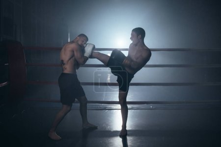 Photo for Two shirtless muscular man fighting Kick boxing combat in boxing ring. High quality photo - Royalty Free Image
