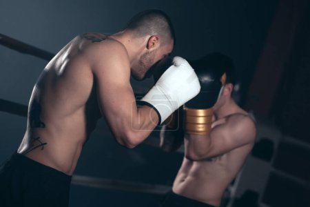 Zwei junge, muskulöse Boxer ohne Hemd, die in einem Boxring kämpfen. Hochwertige Fotografie.