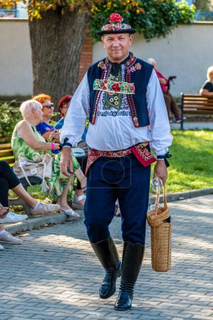 Foto de Uherske Hradiste, República Checa - 11 de septiembre de 2021 Festival folclórico de festivales de vino en Uherske Hradiste, vino, danzas populares, tradiciones. Hombre con Traje Folclórico Tradicional con Cesta de mimbre - Imagen libre de derechos