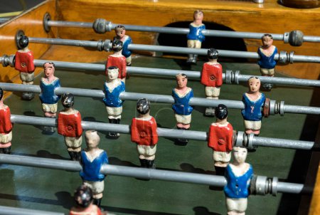 Foto de De arriba miniaturas pintadas a mano de diferentes equipos instalados en la barra de futbolín retro - Imagen libre de derechos