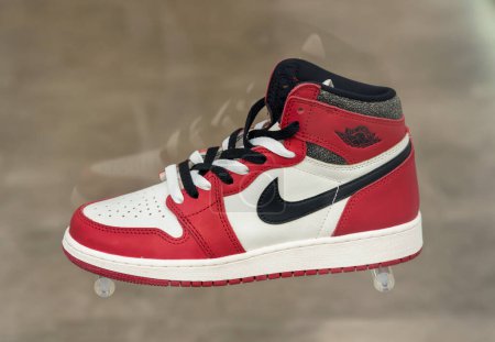 Téléchargez les photos : Baskets tendance Nike Air Jordan de couleurs rouges et blanches et noires placées sur fond gris flou - en image libre de droit