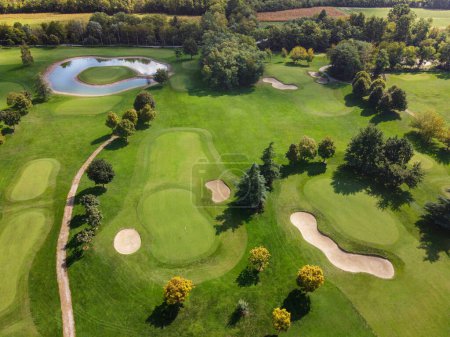 Téléchargez les photos : Vue de drone du terrain de golf avec des arbres et des plantes pendant la journée ensoleillée - en image libre de droit