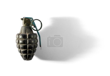 Top view of metal hand grenade with safety clip placed on white background