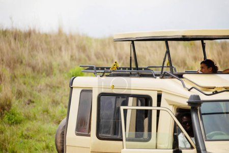 Téléchargez les photos : A girl drinks coffee in a safari jeep in africa and looks at the birds that are very close - en image libre de droit