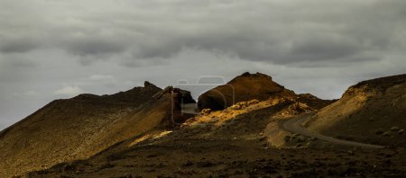 Foto de Increíblemente hermoso paisaje volcánico con arena negra y montañas rojas y un hermoso cielo durante el día en la isla española de Lanzarote - Imagen libre de derechos