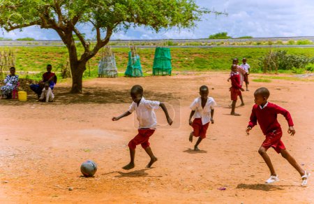 Téléchargez les photos : Diani, Mombasa, 17 octobre 2019, Afrique, Kenya. Enfants africains dans le village de maasai jouant au football près de l'école - en image libre de droit