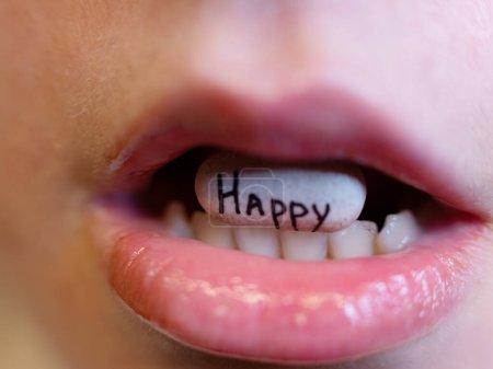 oval white tablet with the inscription happy in the mouth of a teenager. Toxic depression anxiety drama and fear, antidepressant panic attack and psychology concept.