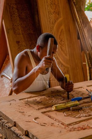 Photo for Stone Town, Zanzibar, Tanzania. 27 March 2018. Master woodcarver at work. Wood shavings, gouges and chisels on the workbench. Close up. master's hands at work - Royalty Free Image