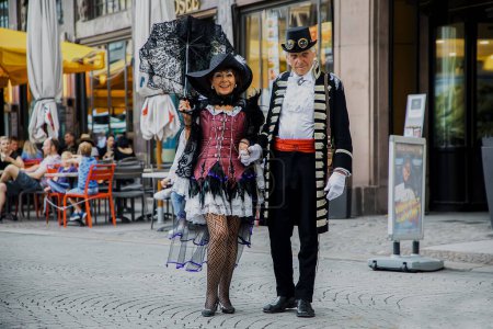 Téléchargez les photos : Leipzig, Allemagne, 9 juin 2019. Festive people in black and red gothic and steampunk costumes at the street - en image libre de droit