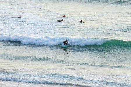 Téléchargez les photos : Silhouette De surfeurs sur la plage coucher de soleil attraper vagues océans. Surf sport bien-être et concept de voyage. - en image libre de droit