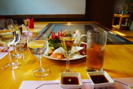Téléchargez les photos : Mains du chef avec spatule sur teppanyaki. cuisson des légumes viande et fruits de mer sur la table chaude hibachi grillage.Cuisine traditionnelle japonaise. Teppan show .vegetables figurines viande, poisson prêt à frire - en image libre de droit