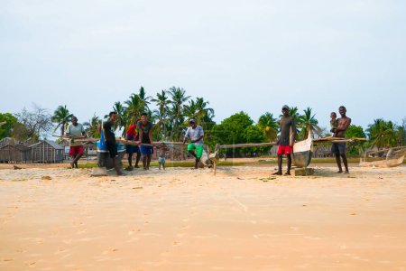 Foto de Batavia, oeste de Madagascar, provincia de Toliara. 18 de octubre de 2023. Habitantes Madagascar tradicional pueblo de pescadores doblar sus redes después de pequeñas capturas en la orilla del océano - Imagen libre de derechos