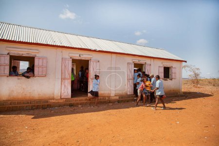 Foto de Miandrivazo, Madagascar 20 octubre 2023. estudiantes de la escuela de Madagascar se apresuran a clase, entran en la construcción de la escuela de un piso de la aldea . - Imagen libre de derechos