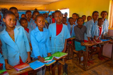 Foto de Miandrivazo, Madagascar 20 octubre 2023. Felices escolares malgaches en clase. los escolares sonríen y miran al maestro. Hay muchos niños en clase. la mayoría de los niños están descalzos - Imagen libre de derechos