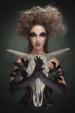 Photo for Mysterious woman portrait. Concept dark art collage of witch holds a dead animal skull in her hands for a ritual. - Royalty Free Image