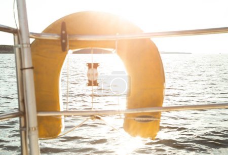 View from a boat on a life jacket. Soft sunbeams illuminate the life jacket on the boat. Boating experience. Parts of a boat. High quality photo.