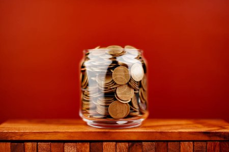 Photo for Coin in glass jar saving money coin coin bank income wages expenditure money financial stability - Royalty Free Image