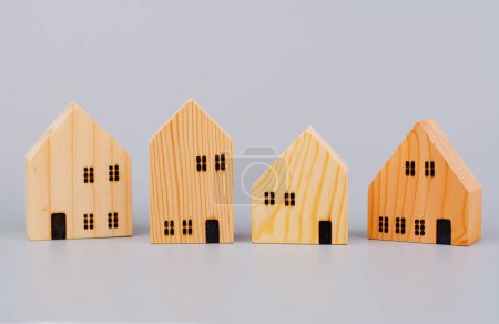 Kleines Holzhaus, Spielzeughaus, Modell-Holzhaus auf hellgrünem Hintergrund.