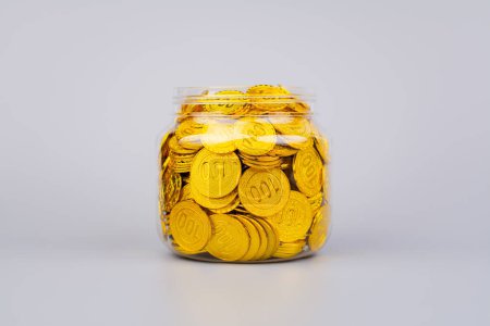 Pièces d'or dans des bocaux en verre, investissement à taux de change élevé et stocks d'or