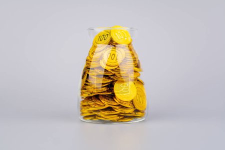 Gold coins in glass jars, high exchange rate investment and gold stocks