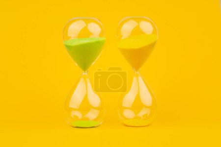 Hourglass on yellow background, time and countdown time limit for urgent work to meet deadlines and appointments.