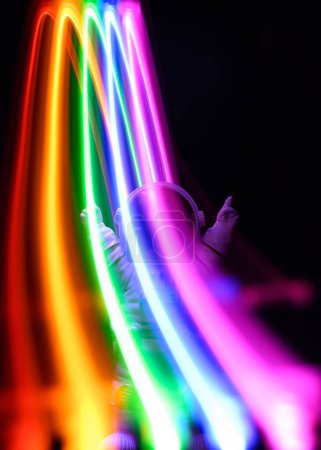 Photo for Colorful rainbow lights with a spaceman on a dark background - Royalty Free Image