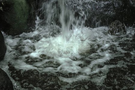 Paisaje de agua que fluye de una pequeña cascada. Material de fondo de cascada.