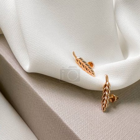 Photo for Stylish gold spikelet stud earrings in pink gold , which reflects a modern vision of Ukrainian traditions. - Royalty Free Image