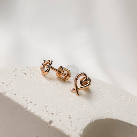 Photo for Stylish gold stud earrings in pink gold in the shape of hearts. - Royalty Free Image