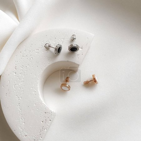 Black onyx gemstone stud earrings in white gold and white enamel stud earrings in rose gold.