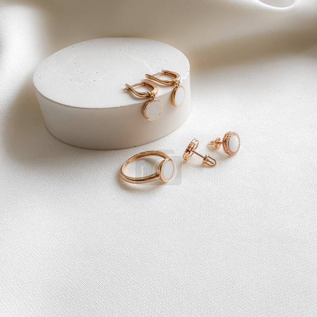Photo for Stylish gold set ring earrings with white enamel. - Royalty Free Image