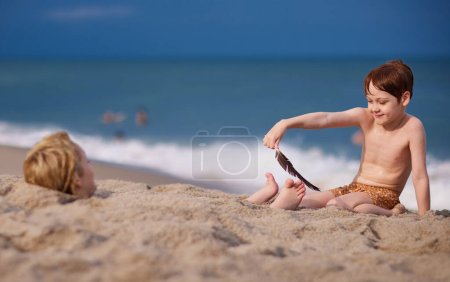 Téléchargez les photos : Les enfants s'amusent sur la plage de sable fin. activité estivale. vacances côtières - en image libre de droit