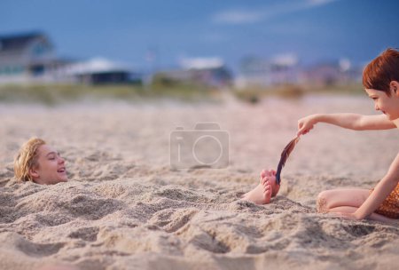 Foto de Niños divirtiéndose en la playa de arena. actividad de verano. vacaciones costeras - Imagen libre de derechos