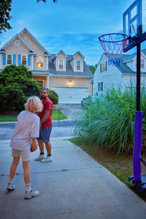 Photo for Father and son having fun playing basketball on the driveway of their home. active lifestyle. neighborhood sports - Royalty Free Image