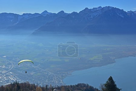 Téléchargez les photos : Parapentes sur le lac Léman en Suisse avec des montagnes enneigées en arrière-plan - en image libre de droit